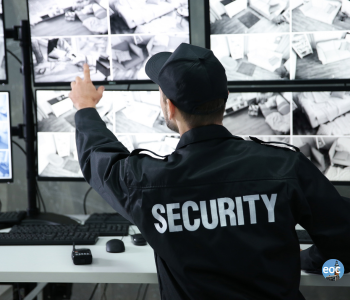 image of a security guard looking at computer monitors